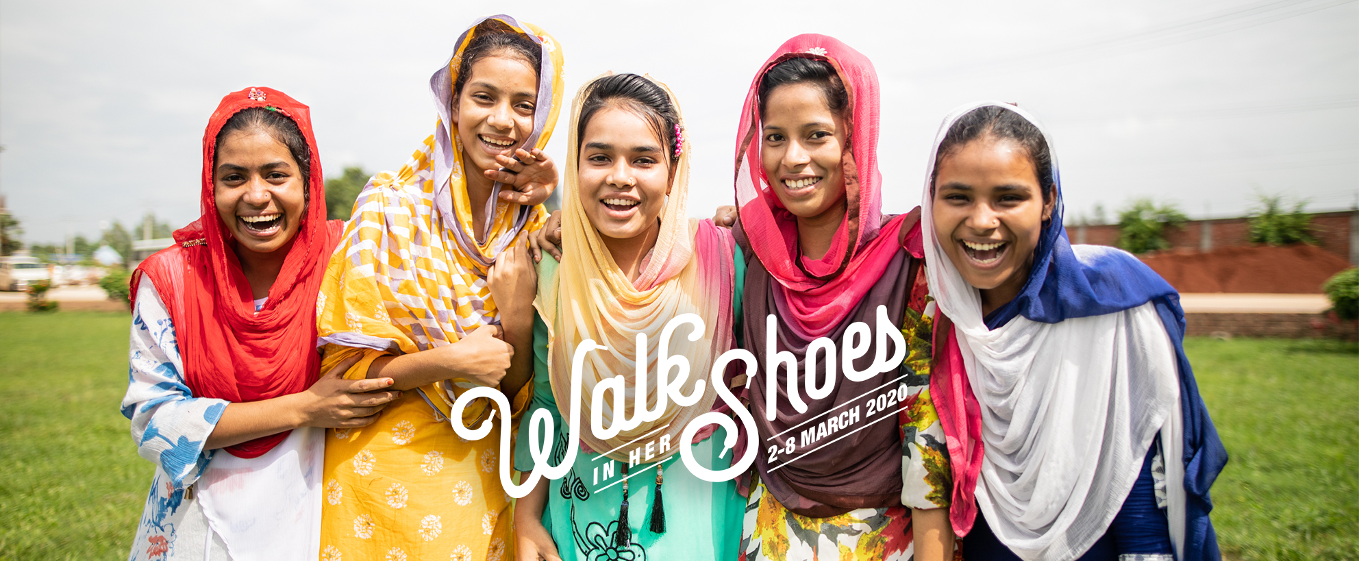 Walk in her Shoes logo. Image of girls laughing.